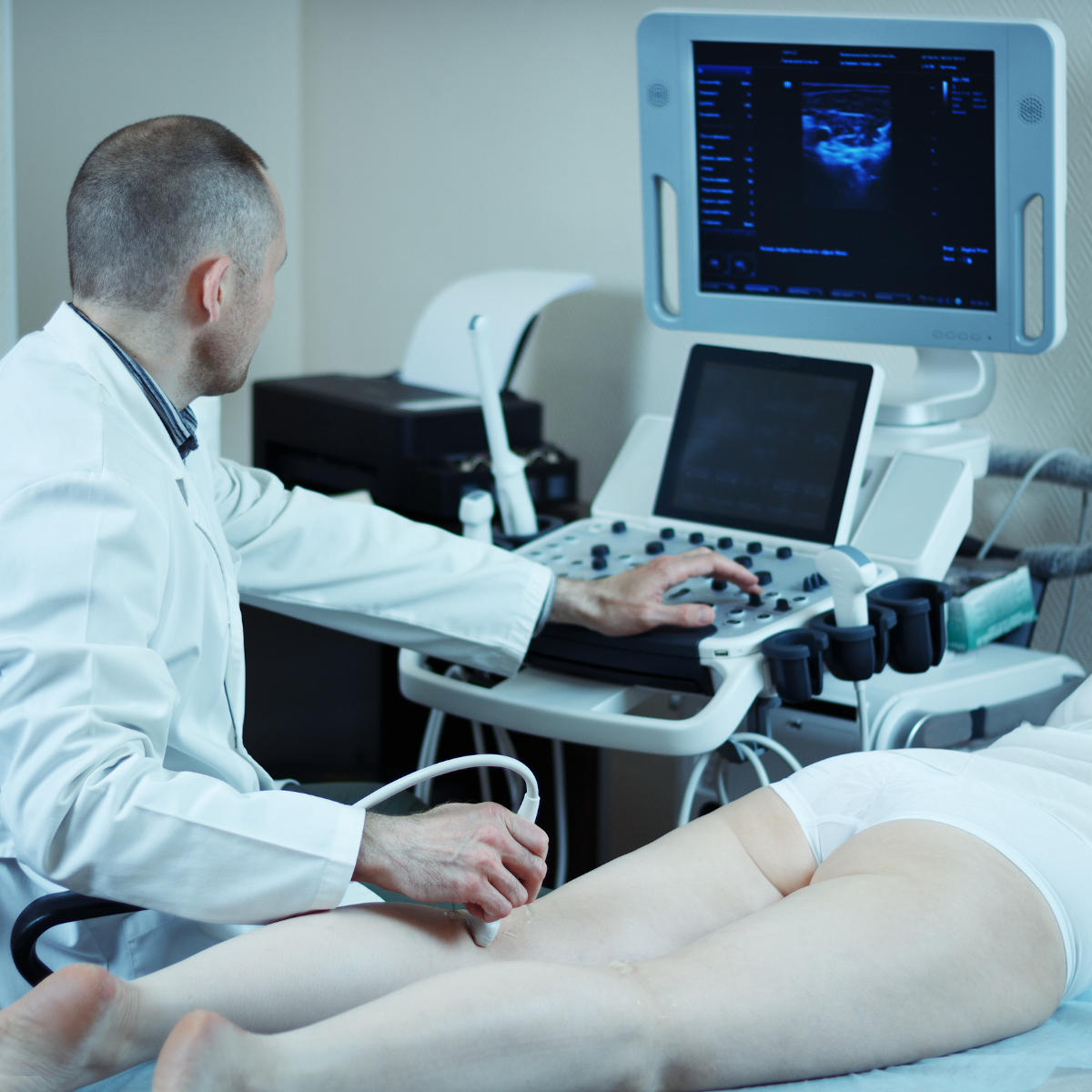 Medico che sottopone una paziente all'esame ecocolordoppler