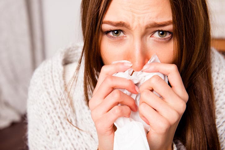 Donna che si soffia il naso a causa della congestione