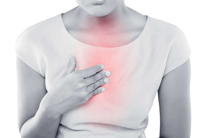 Immagine di una donna che appoggia la mano al petto, a causa del bruciore causato dal reflusso.