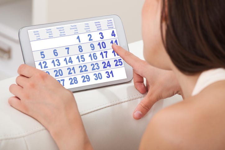 Fotografia di una donna che consulta un calendario sul tablet per calcolare il possibile ritardo.