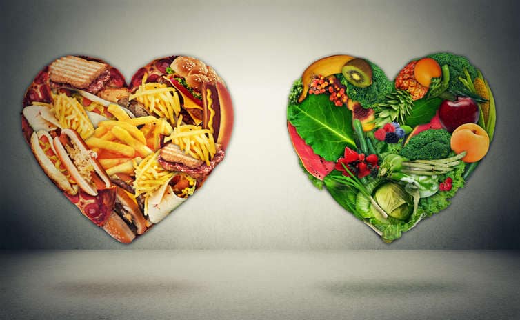 Fotografia con due cuori che racchiudono rispettivamente il cibo spazzatura e gli alimenti cardine di una sana alimentazione.