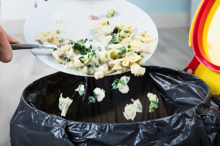 Piatto di pasta che finisce nella spazzatura a causa della perdita di appetito.