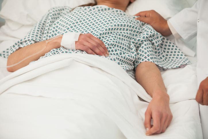 Signora in coma in un letto d'ospedale