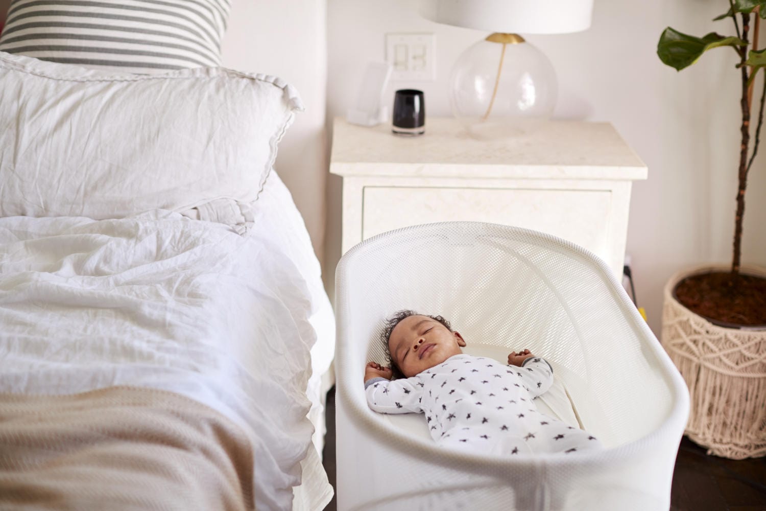 Bimbo che dorme in culla accanto al letto dei genitori