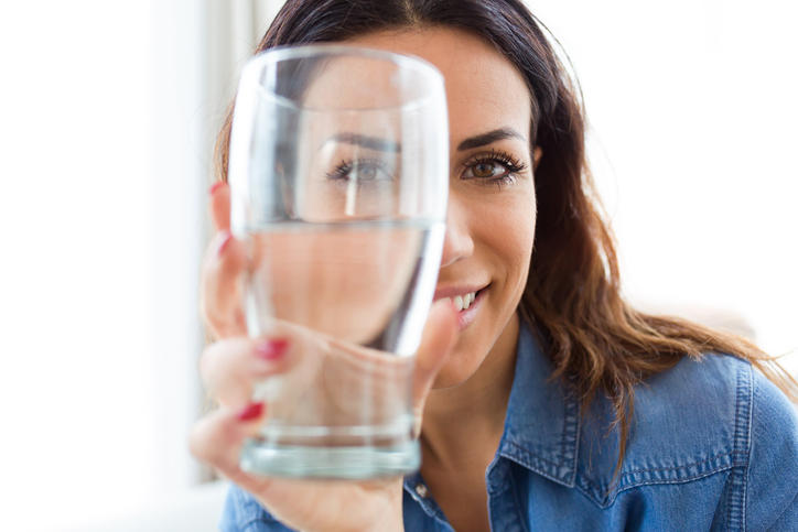 Donna con in mano un bicchiere d'acqua