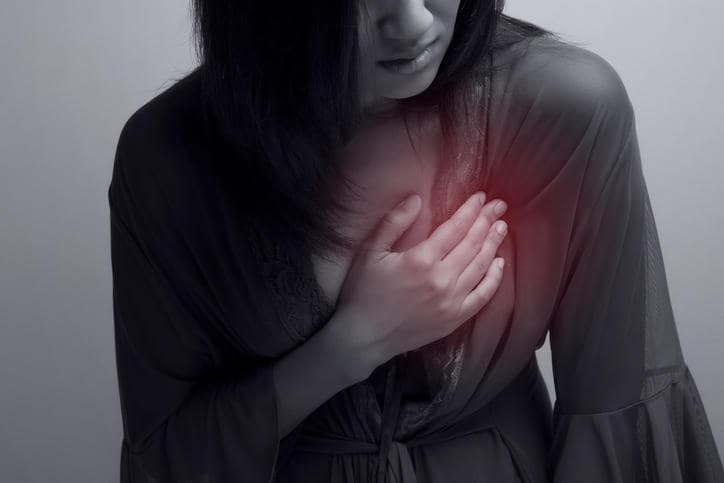 Fotografia di una donna che si tocca il petto a causa di dolore