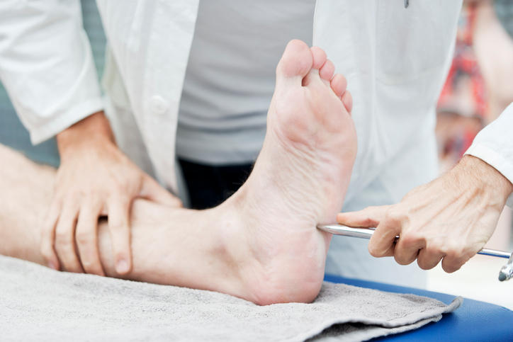 Medico che verifica la sensibilità cutanea di un piede attraverso una punta