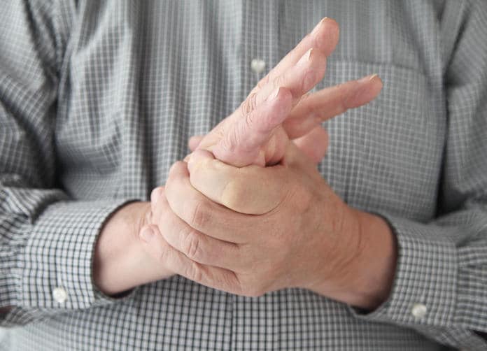 Primo piano di un uomo che si tocca la mano a causa di formicolio