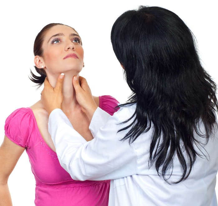 Fotografia di una specialista che visita una donna in gravidanza per rilevare eventuali anomalie della tiroide.