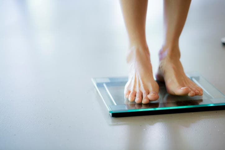Primo piano di due piedi femminili su una bilancia