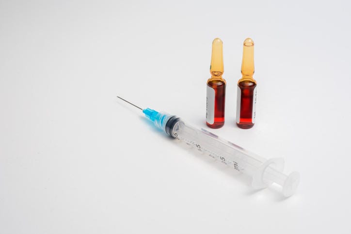 Fotografia di una siringa e fiale di vitamina b12