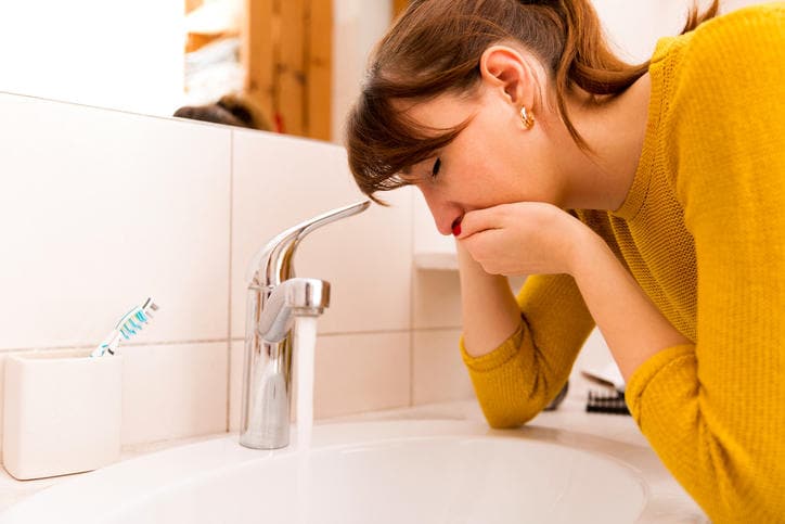Ragazza che vomita nel lavandino