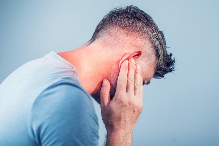 Uomo che si tocca l'orecchio a causa di dolore