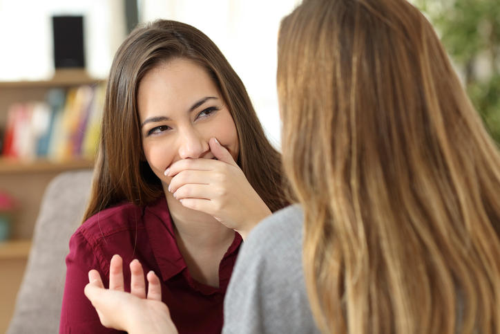 Donna che si copre la bocca a causa dell'imbarazzo provocato dalla scialorrea