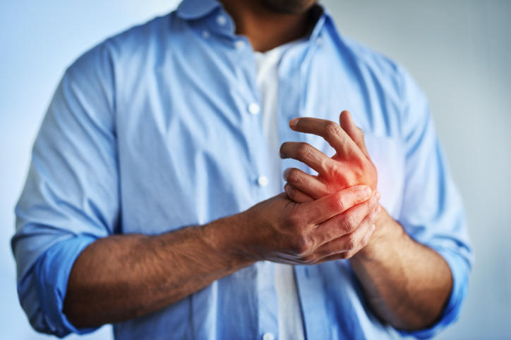 Uomo che si tocca mignolo e anulare della mano