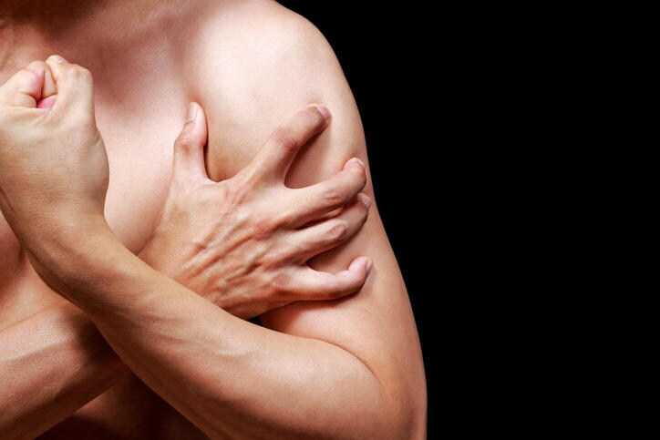 Uomo che si tocca il muscolo del braccio a causa del dolore da miosite