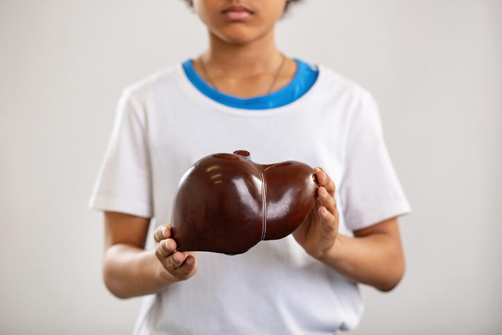 Bambino che tiene in mano il modello di un fegato umano, uno degli organi interessati dalla sindrome
