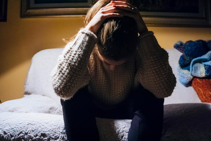 Donna che soffre di depressione seduta sul letto