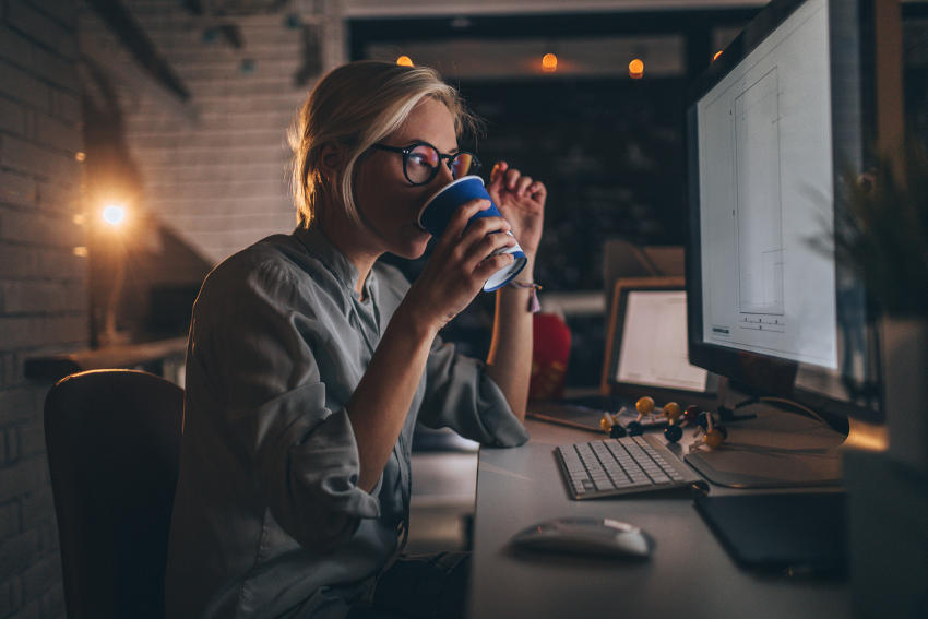 Donna che beve caffè per lavorare di notte