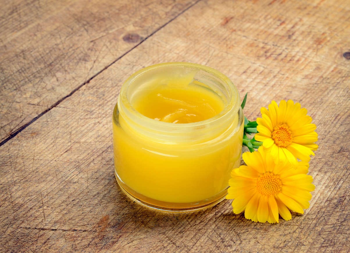 Crema a base di calendula con accanto un fiore