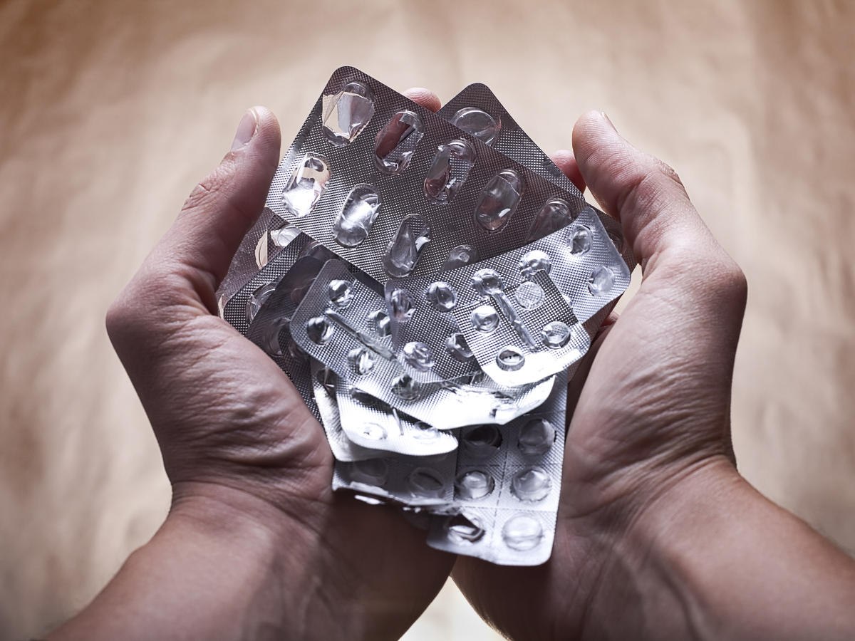 Primo piano di due mani che tengono blister di farmaci vuoti