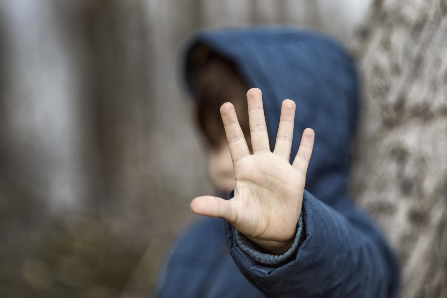 Bambino che impone la mano aperta di fronte a sé