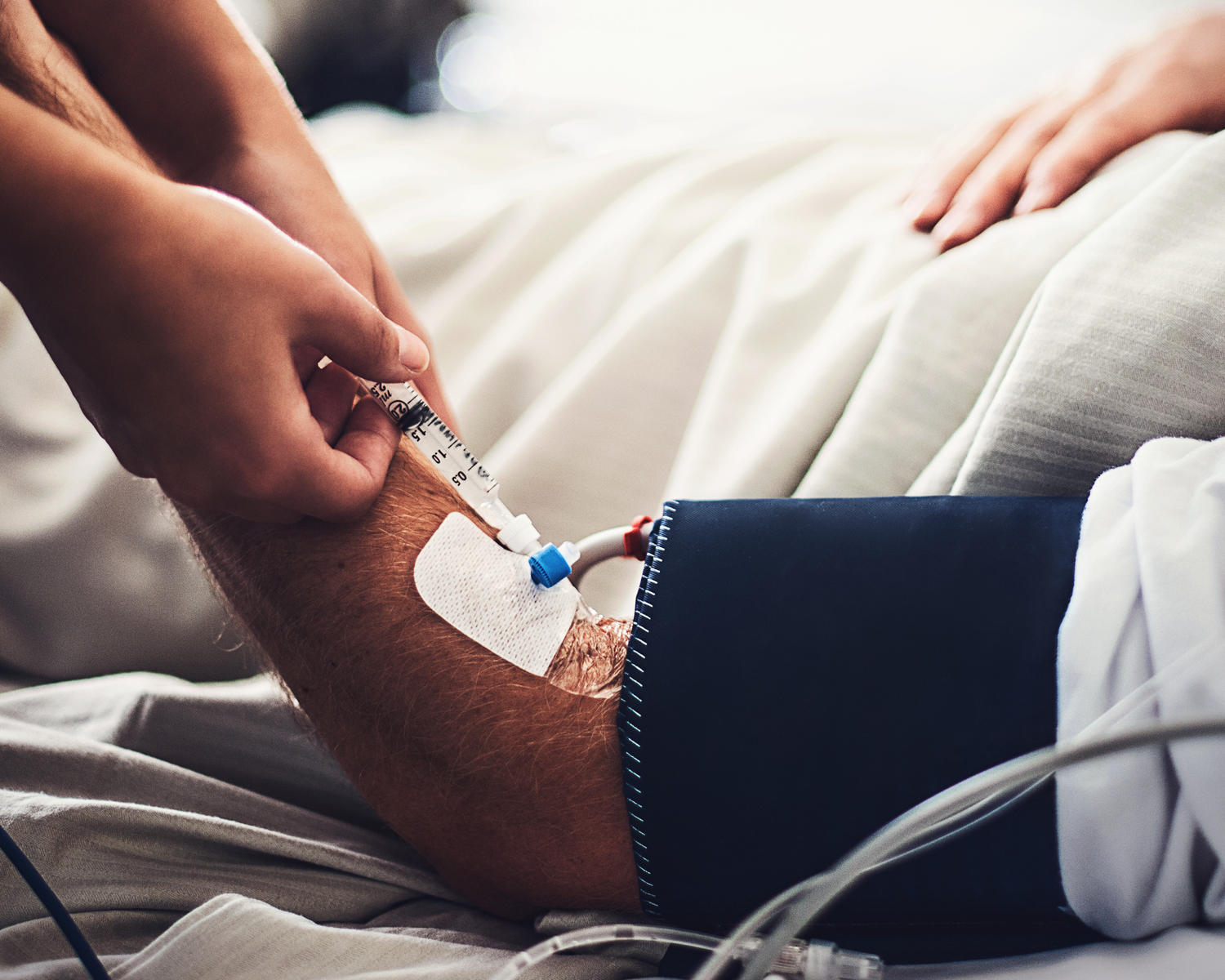 Medico che inietta un farmaco nel braccio di un paziente.