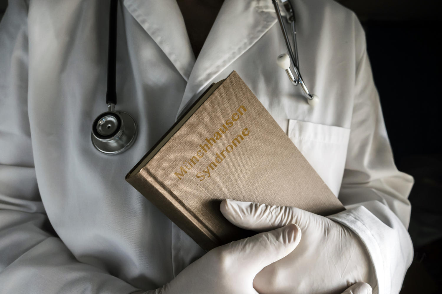 Medico che tiene in mano un libro con il titolo "M&uuml;nchhausen Syndrome"