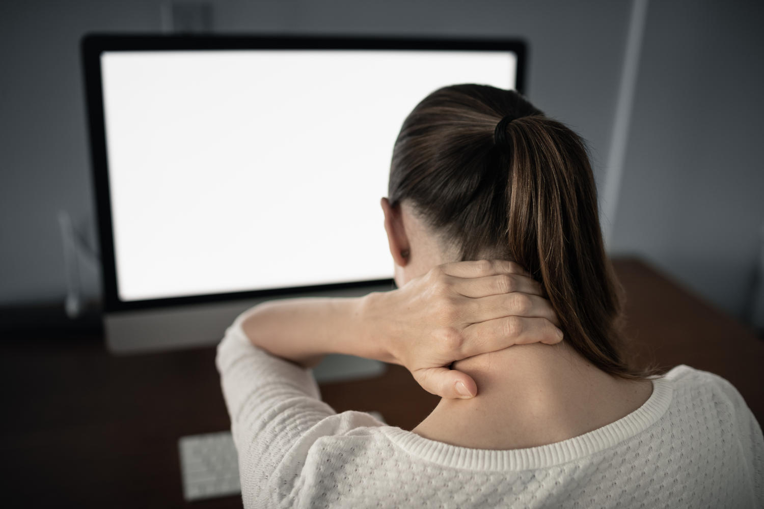 Collo rigido in una donna seduta di fronte al PC