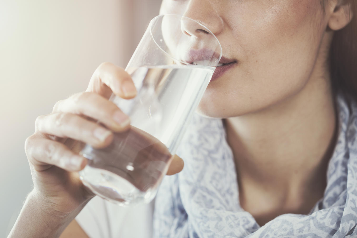 Donna che beve un bicchiere d'acqua