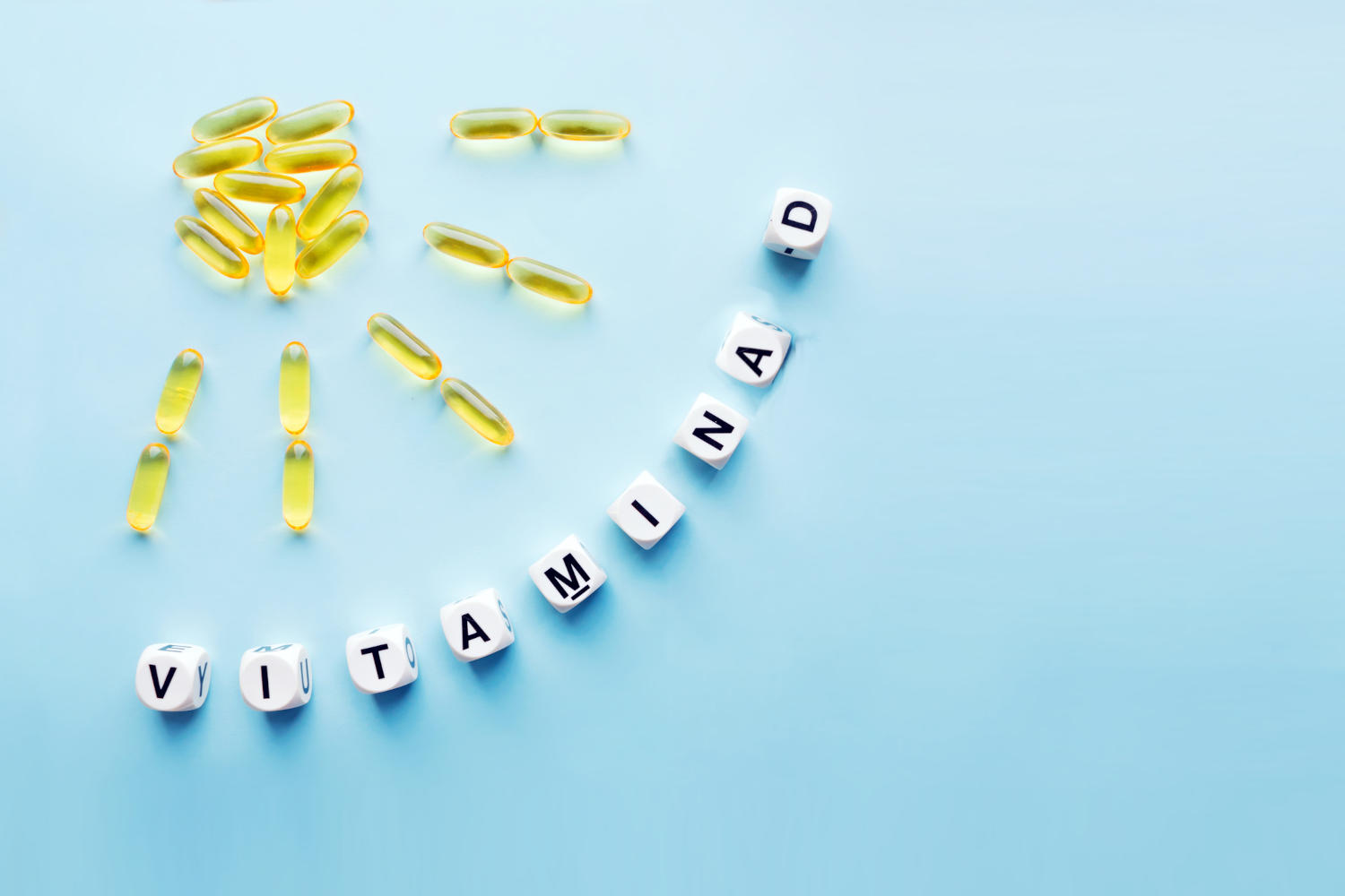 Capsule di integratore di vitamina D che disegnano un sole