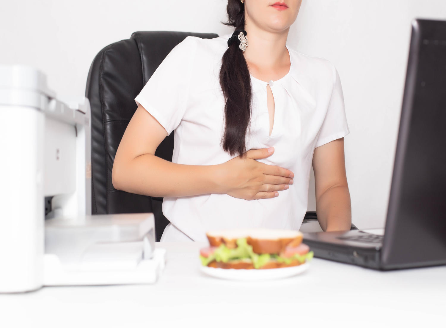 Donna con sintomi di dispepsia al lavoro