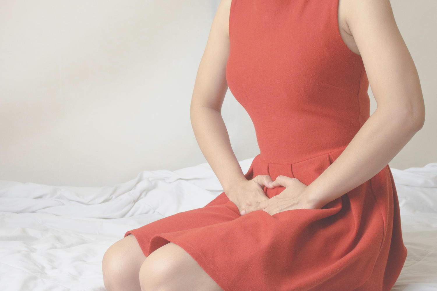 Donna che appoggia le mani a livello pelvico a causa di fastidio