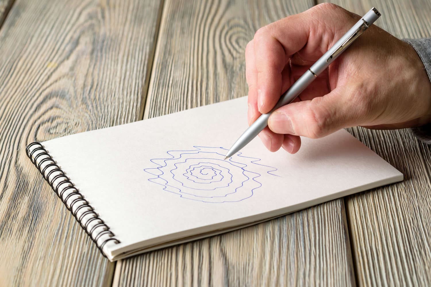 Mano che disegna una spirale