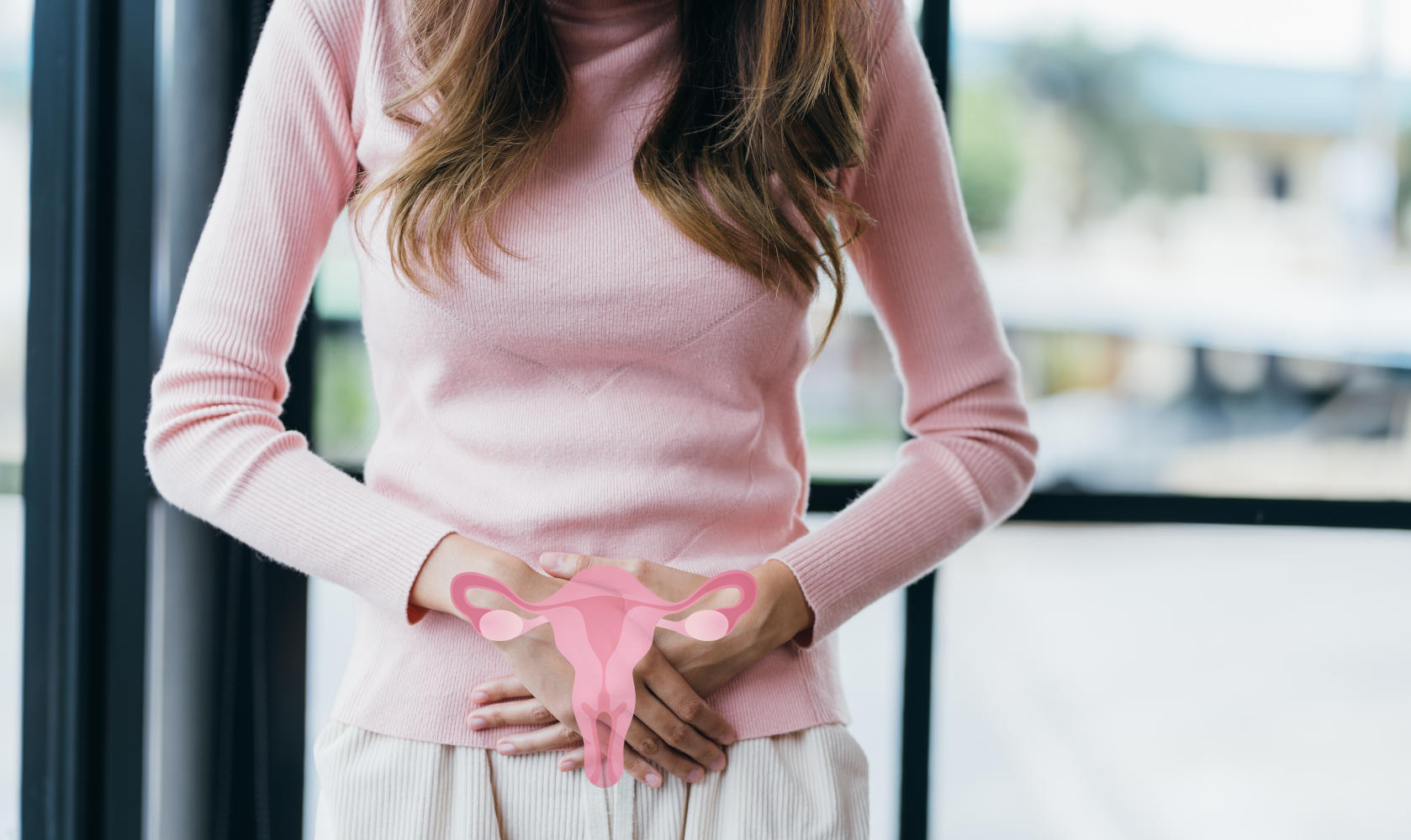 Donna con le mani appoggiate sul ventre e disegnato in sovraimpressione l'utero