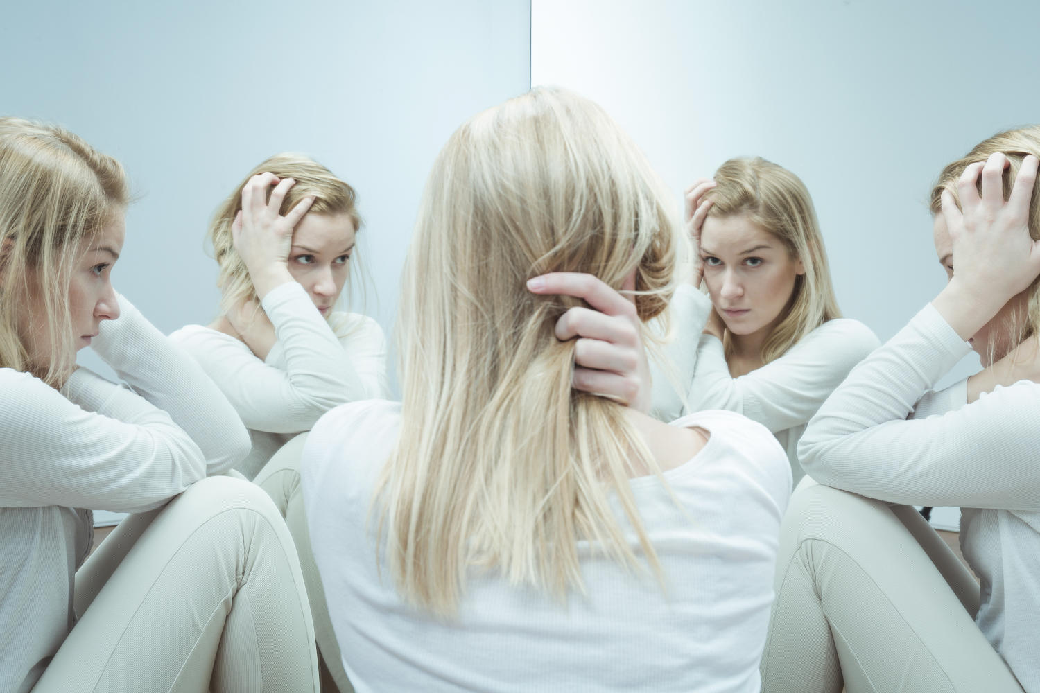 Immagine concettuale di donna di fronte a vari specchi con immagini differenti