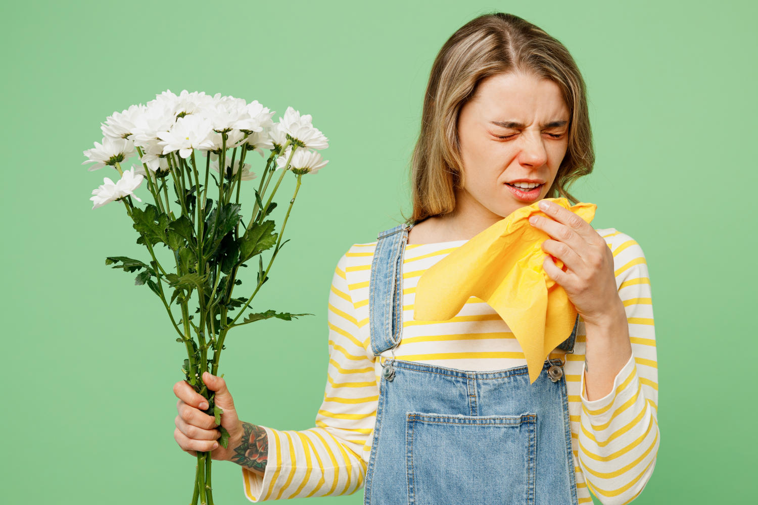 Donna con un mazzo di fiori in mano e che sta per starnutire