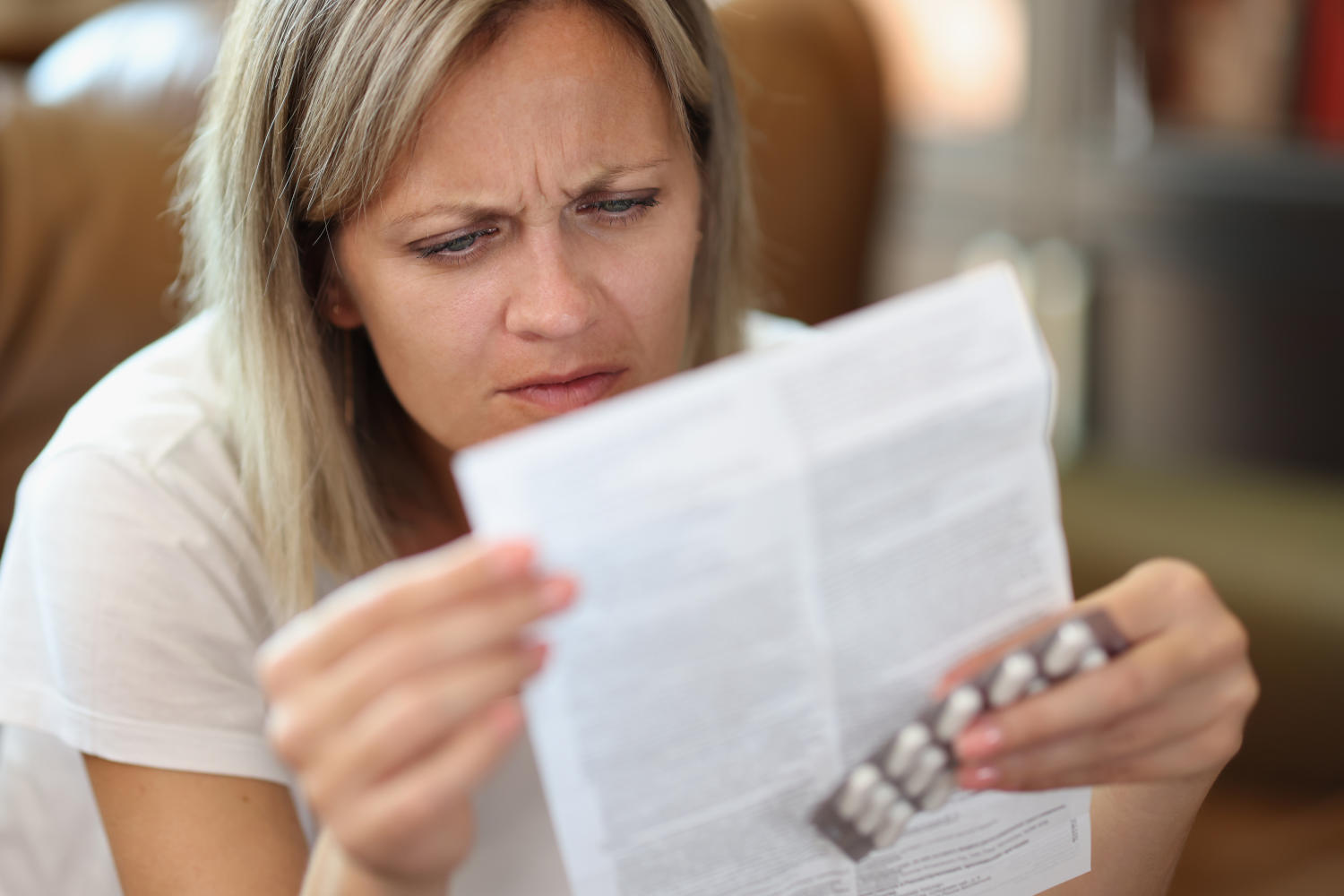 Donna che legge il foglietto illustrativo di un farmaco