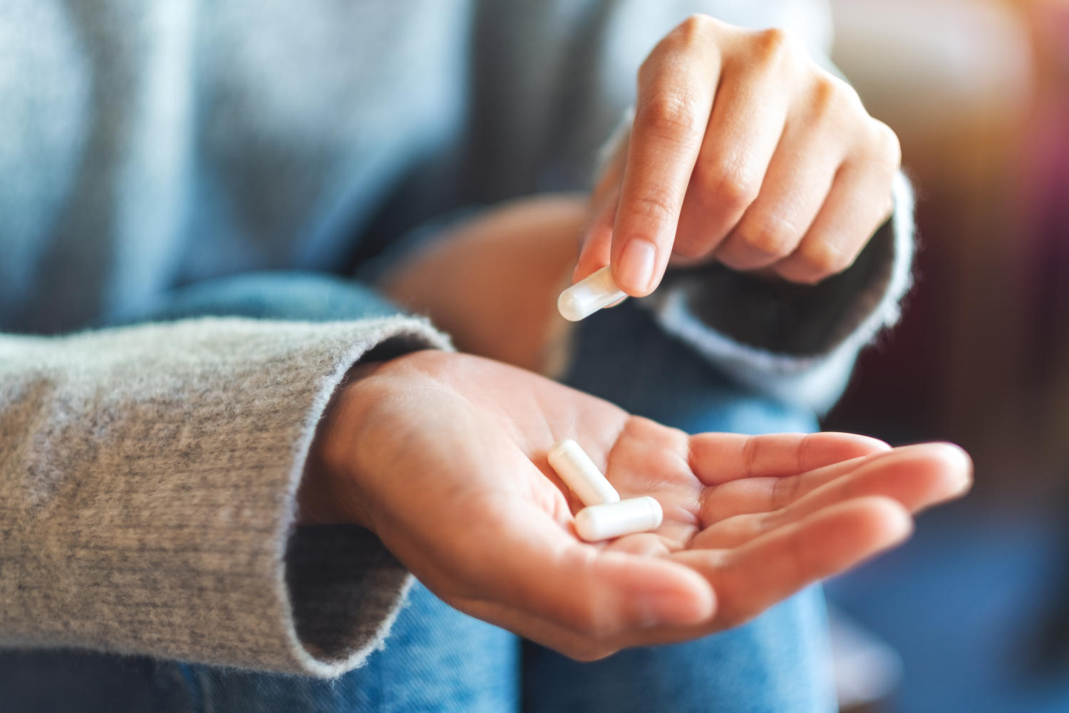 Capsule in mano a una donna