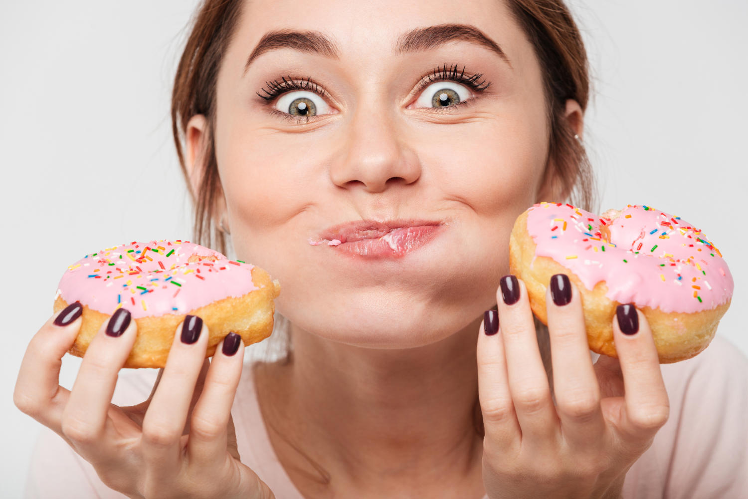 Ragazza che mangia ciambelle e guarda in camera