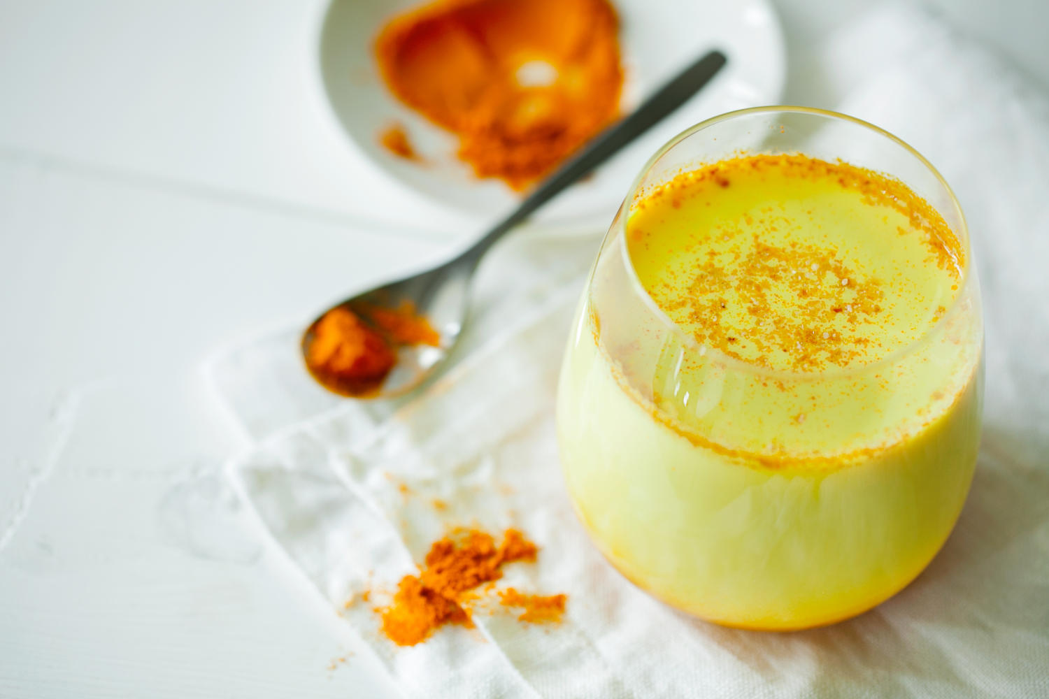 Bicchiere contenente Golden-Milk, bevanda tradizionale a base di curcuma