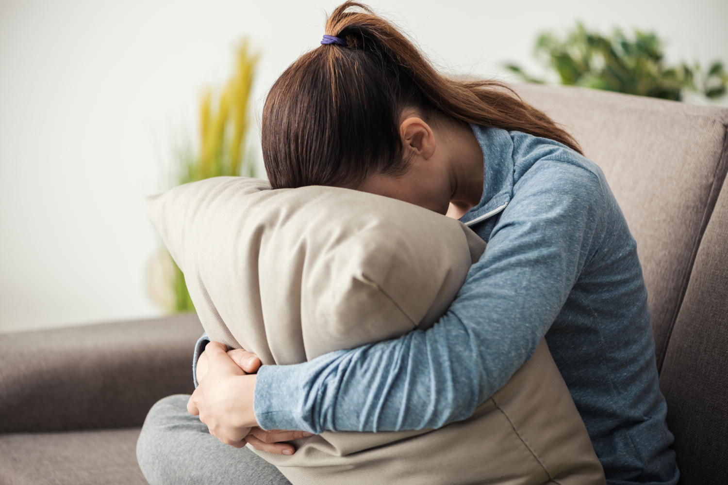 Donna depressa con la testa appoggiata a faccia in g&ugrave; sul cuscino