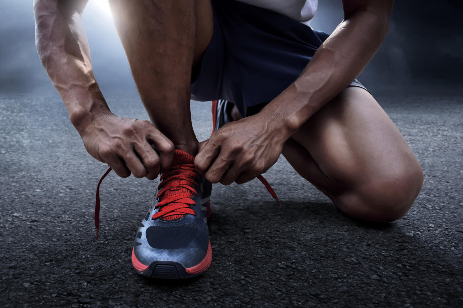 Uomo che si allaccia le scarpe da corsa