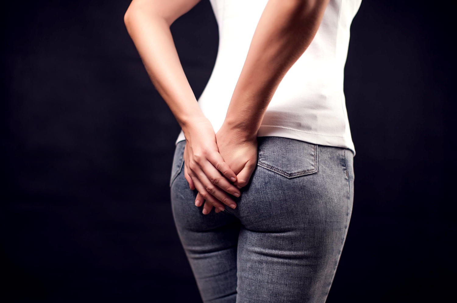 Donna che si tocca i glutei a causa di fastidio