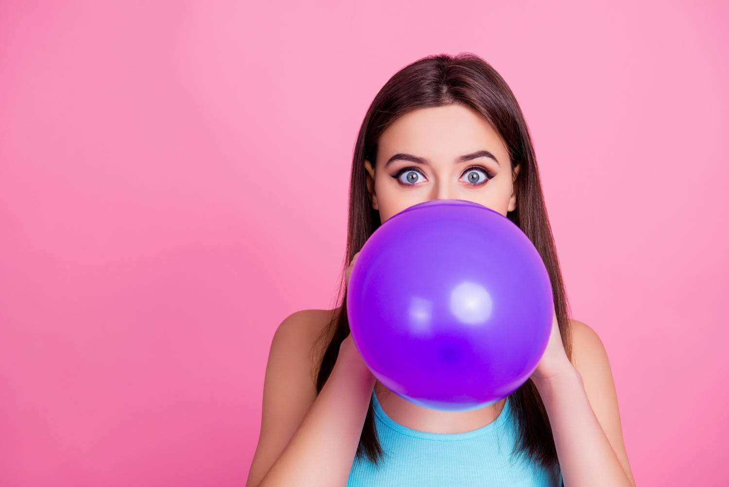 Ragazza che gonfia un palloncino viola