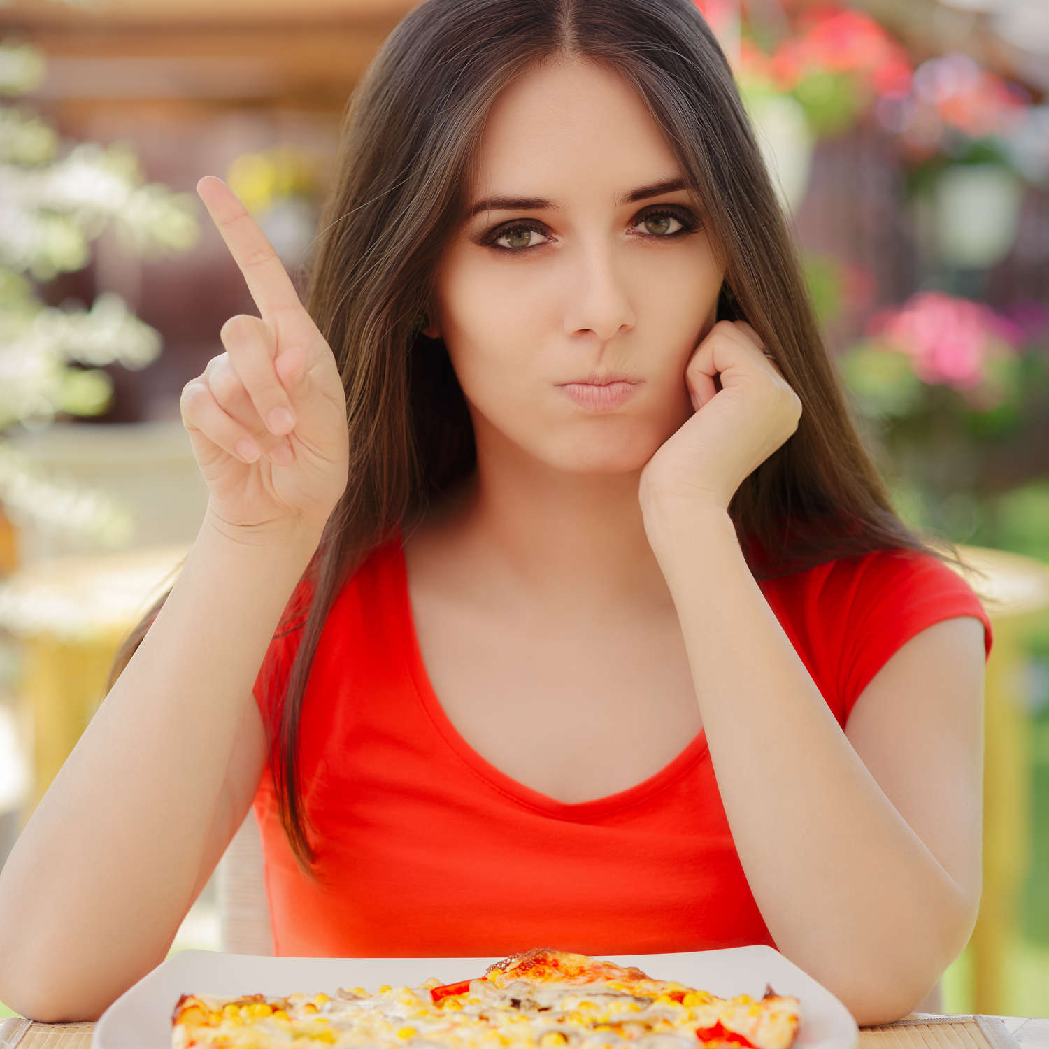 Ragazza che fa no con il dito di fronte alla pizza