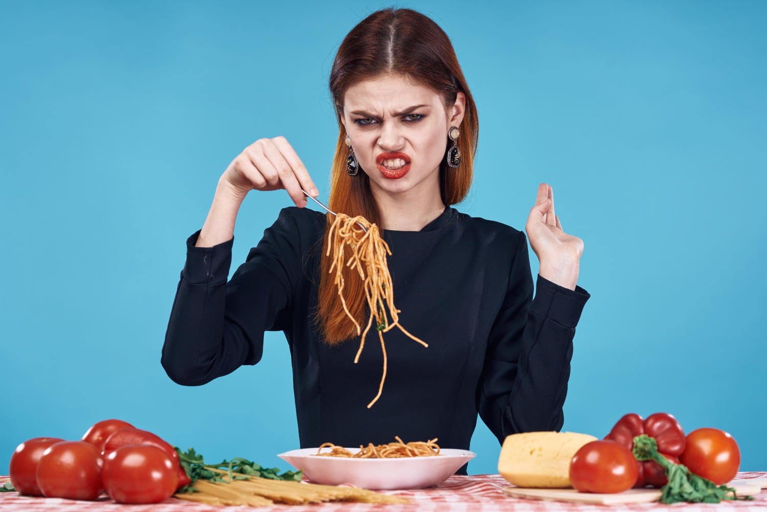 Donna con espressione disgustata che guarda una forchettata di pasta