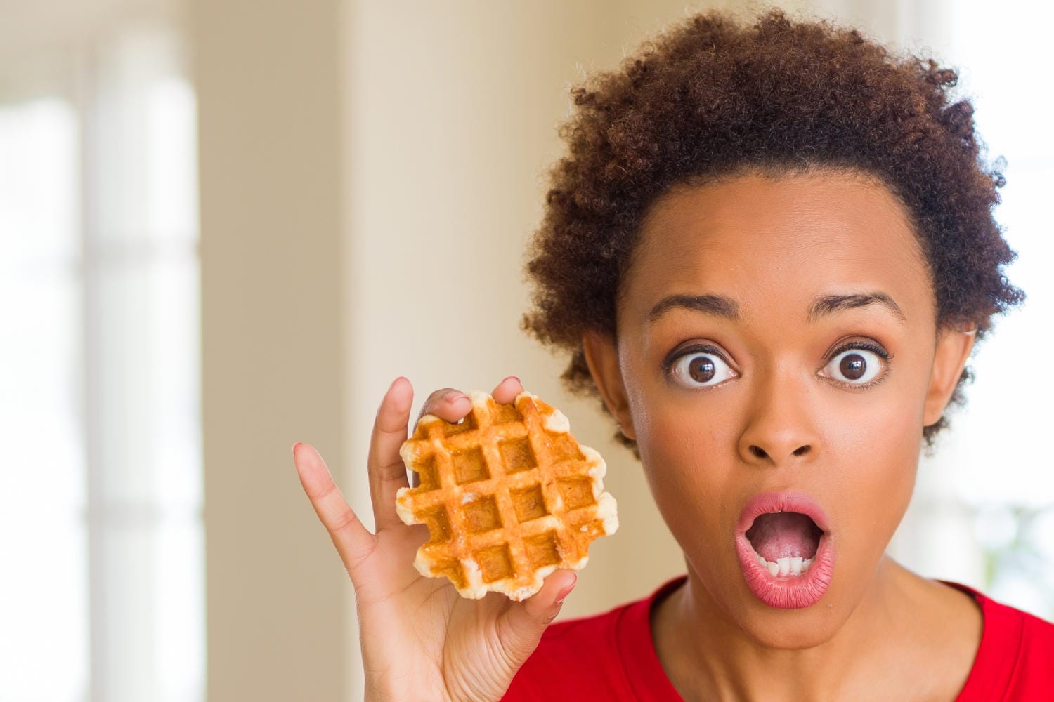 Ragazza che mostra un pancake con sguardo stupito