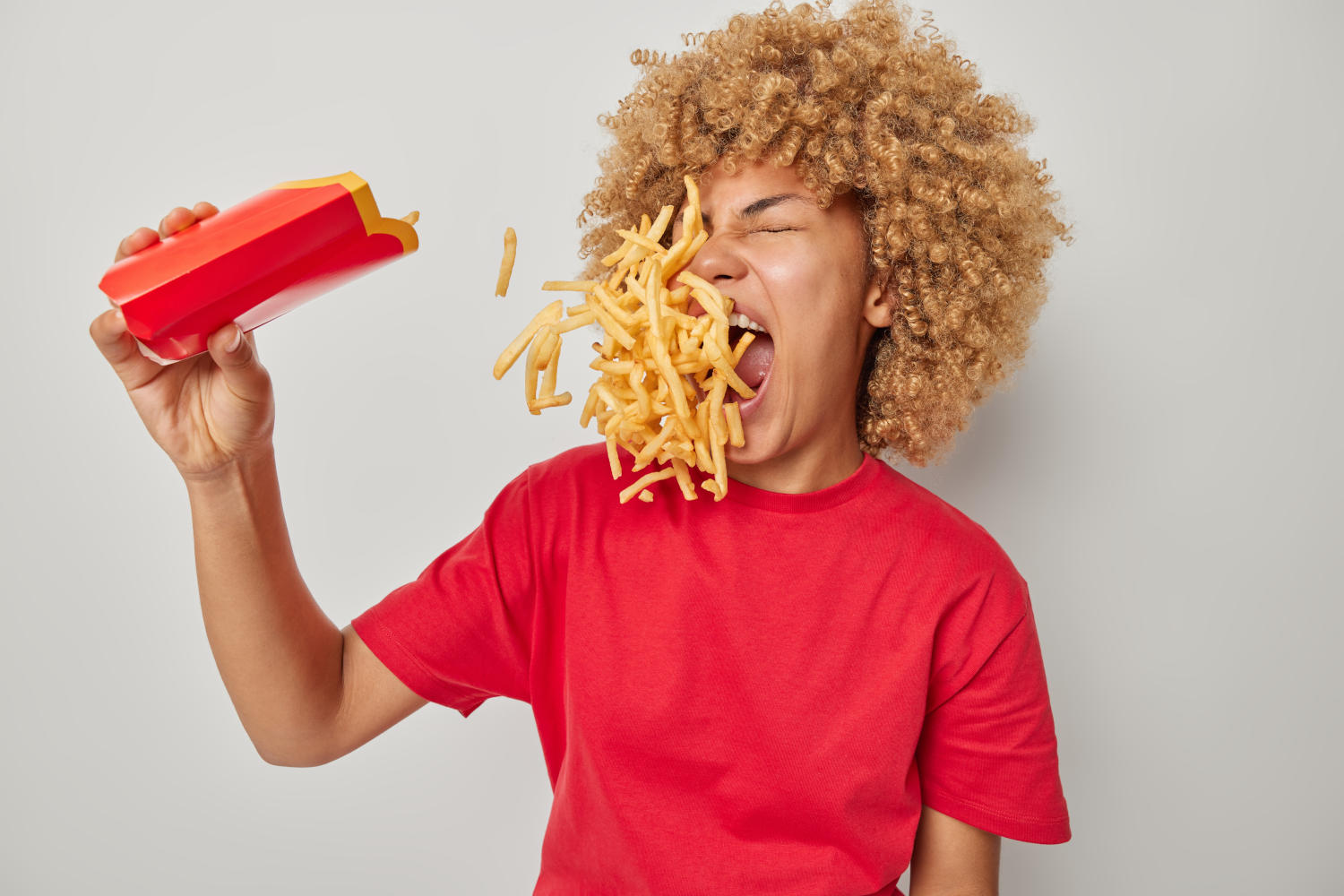 Ragazza che si tira addosso delle patatine