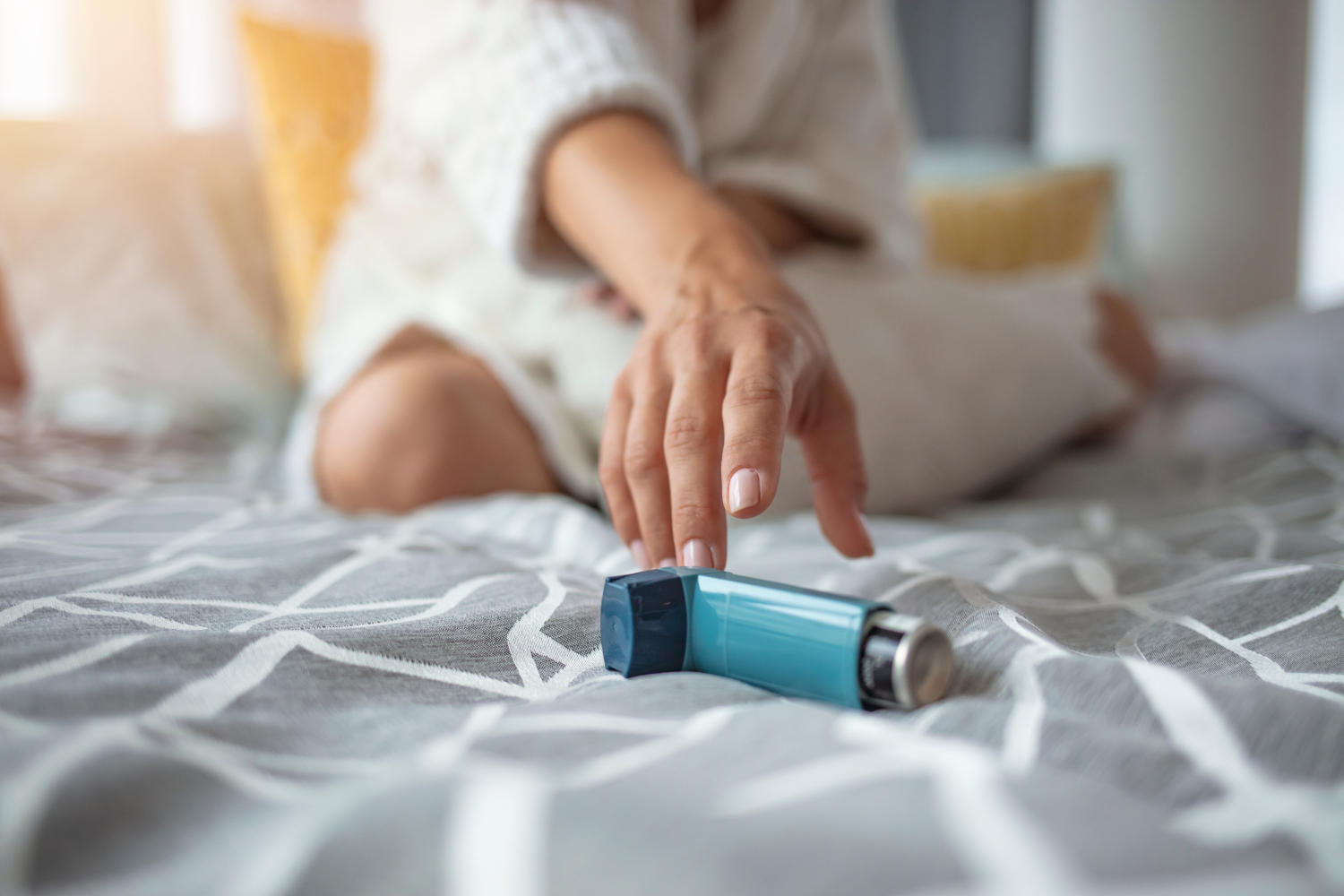 Ragazza che allunga la mano per prendere uno spray per l'asma